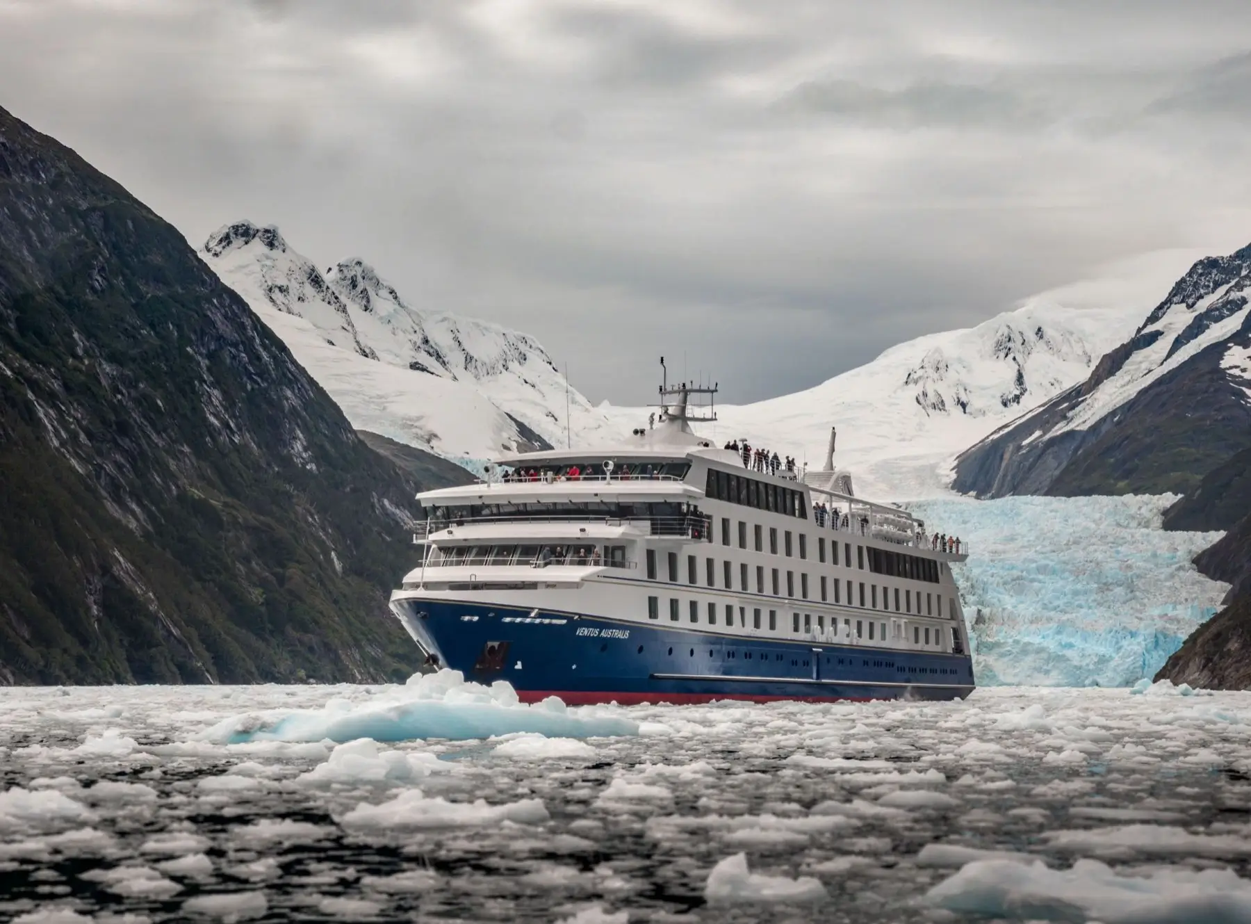 Ventus Australis cruise ship sailing through icebergs toward a glacier in the Patagonian fjords