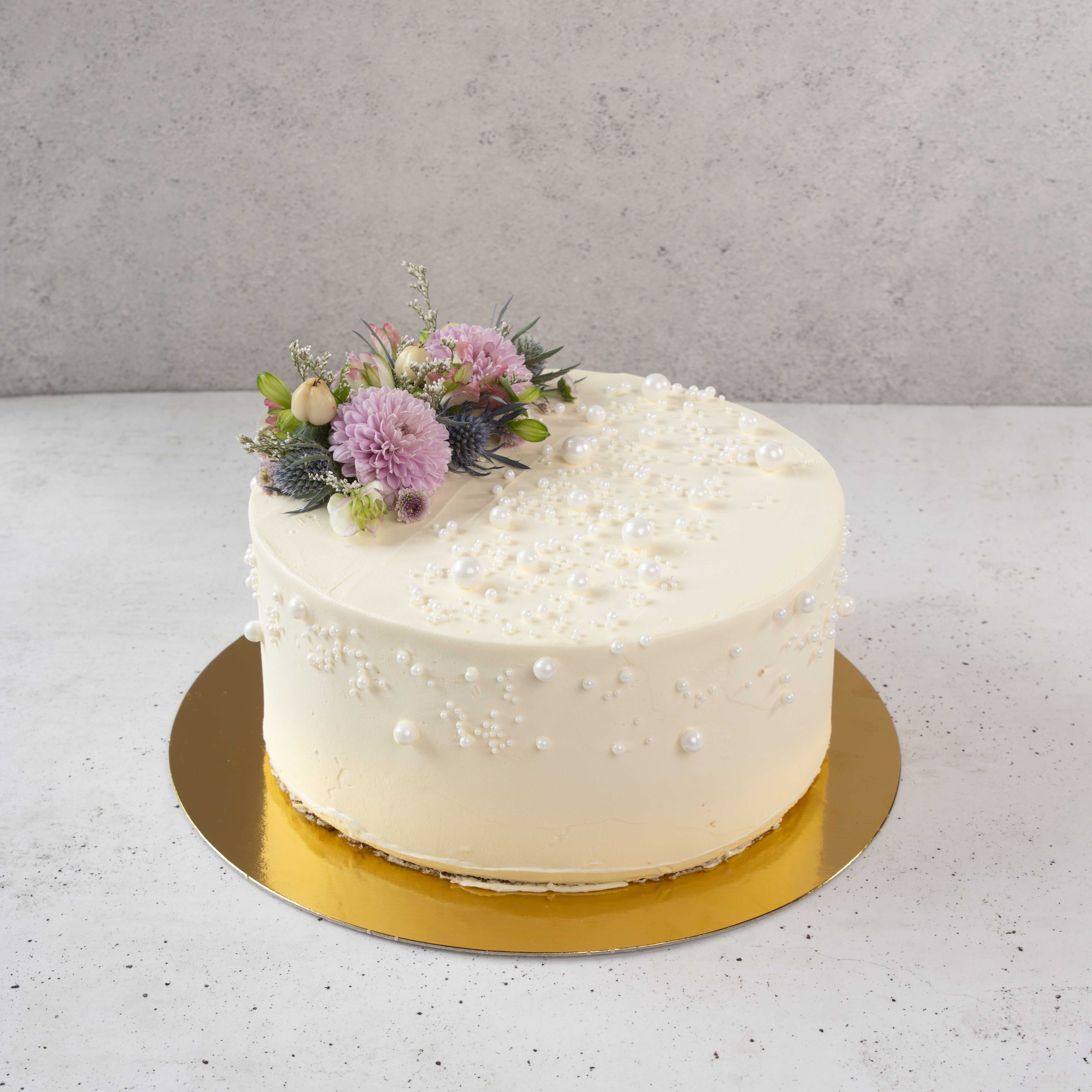 Torta de matrimonio con flores lilas y perlas