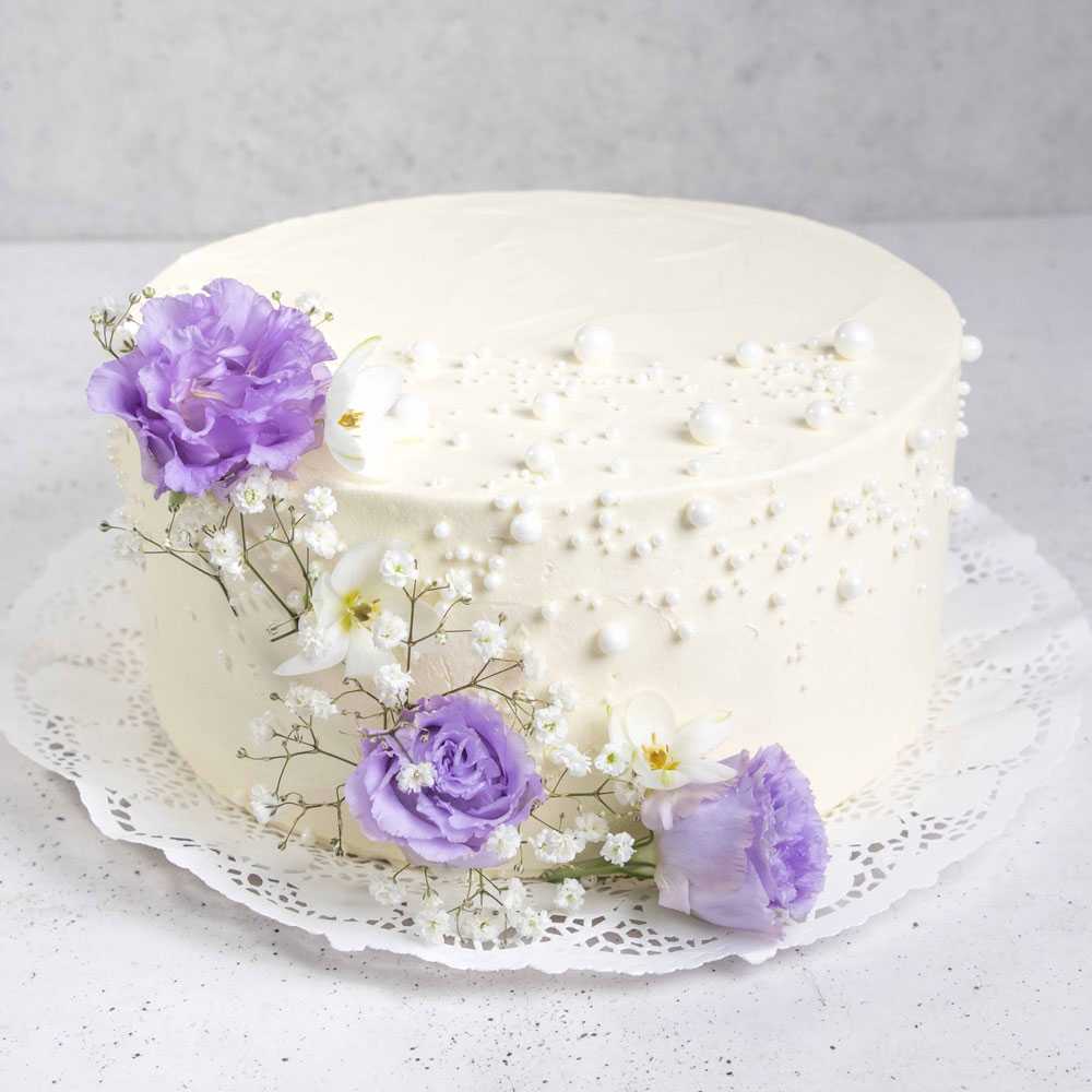 Detalle de flores lila sobre torta de matrimonio
