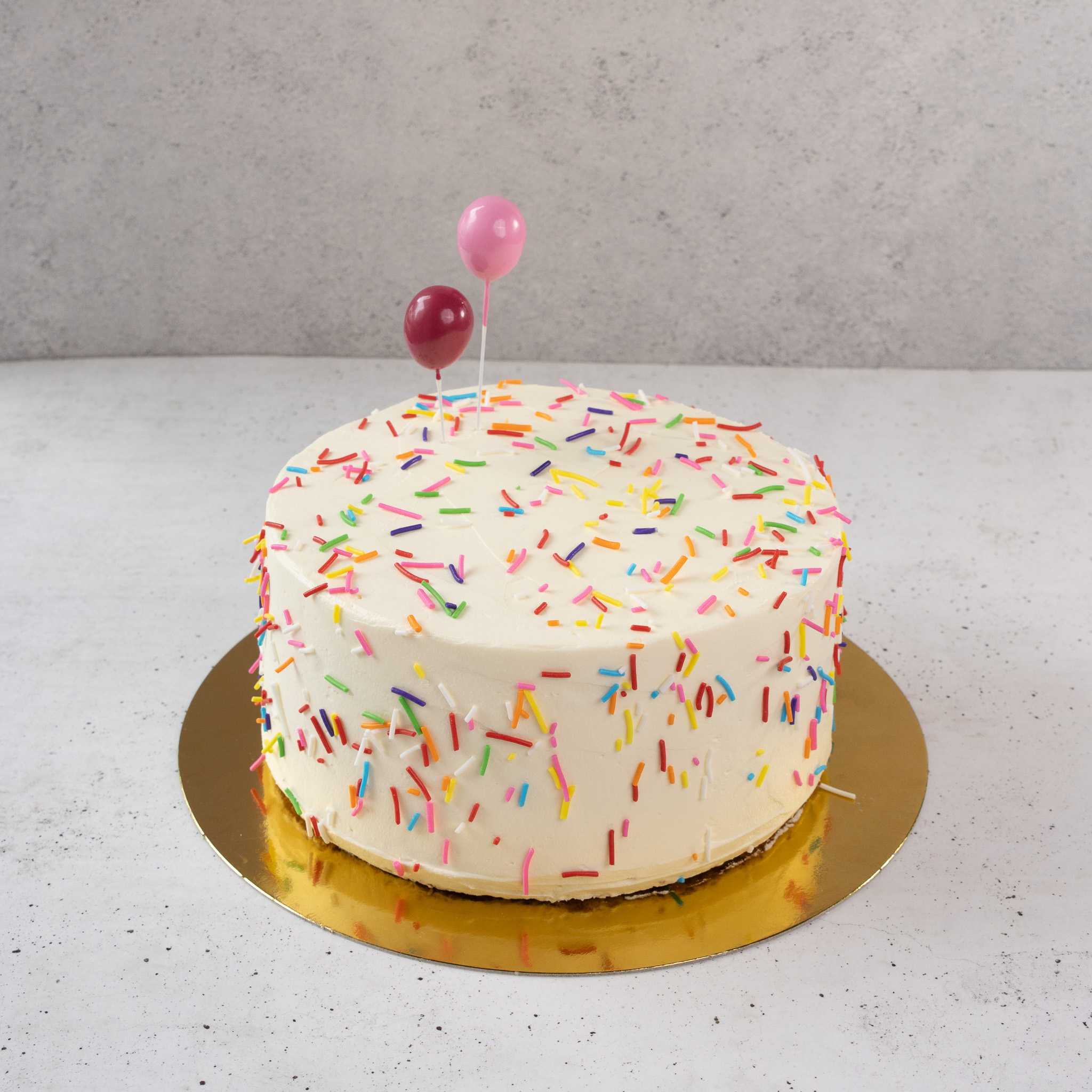 Torta de cumpleaños con confetti y globos decorativos