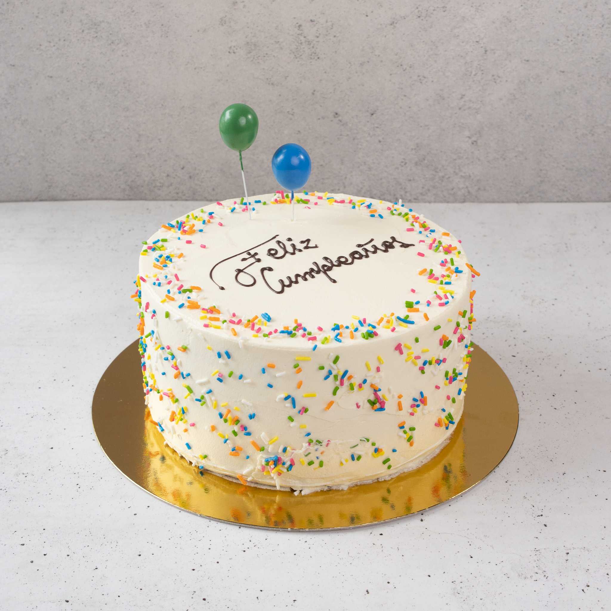 Torta de cumpleaños con confetti y mensaje escrito