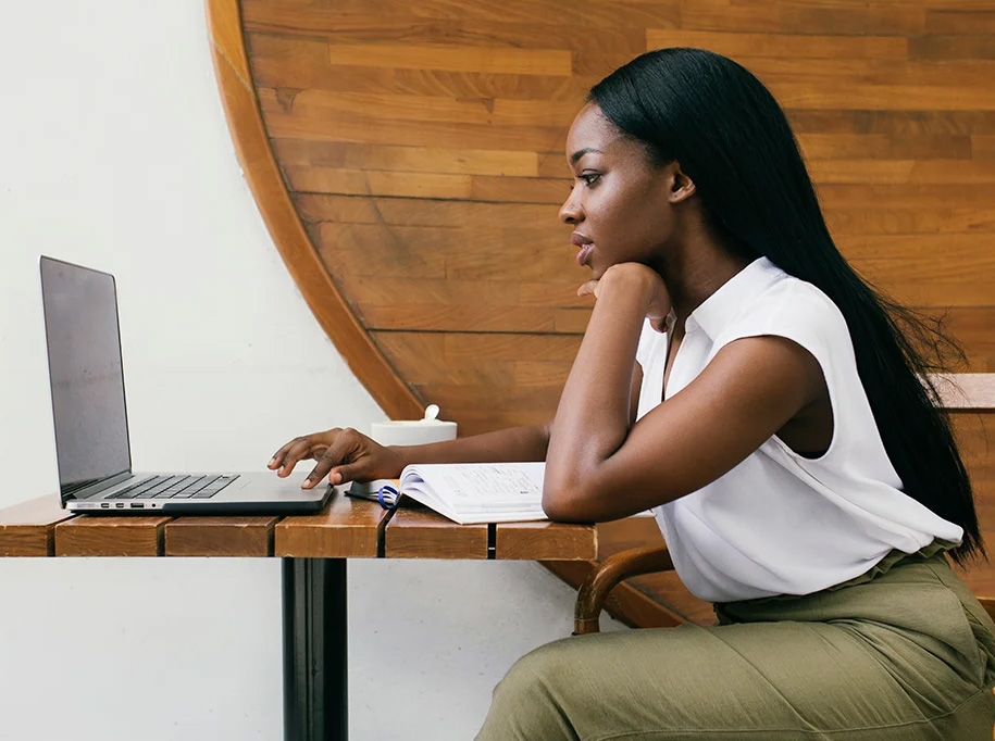 woman looking at computer and doing classwork