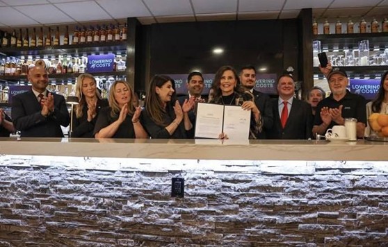 Democratic Leader Ranjeev Puri with Michigan Governor Gretchen Whitmer and colleagues at a restaurant holding a signed bill. Democratic Leader Ranjeev Puri with Michigan Governor Gretchen Whitmer and colleagues at a restaurant holding a signed bill.