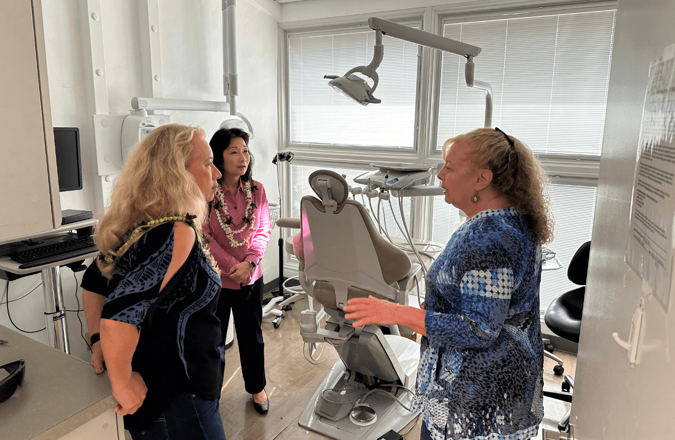 Lt. Gov. Sylvia Luke, a legislator, and community member talking in a dentist's office. 
