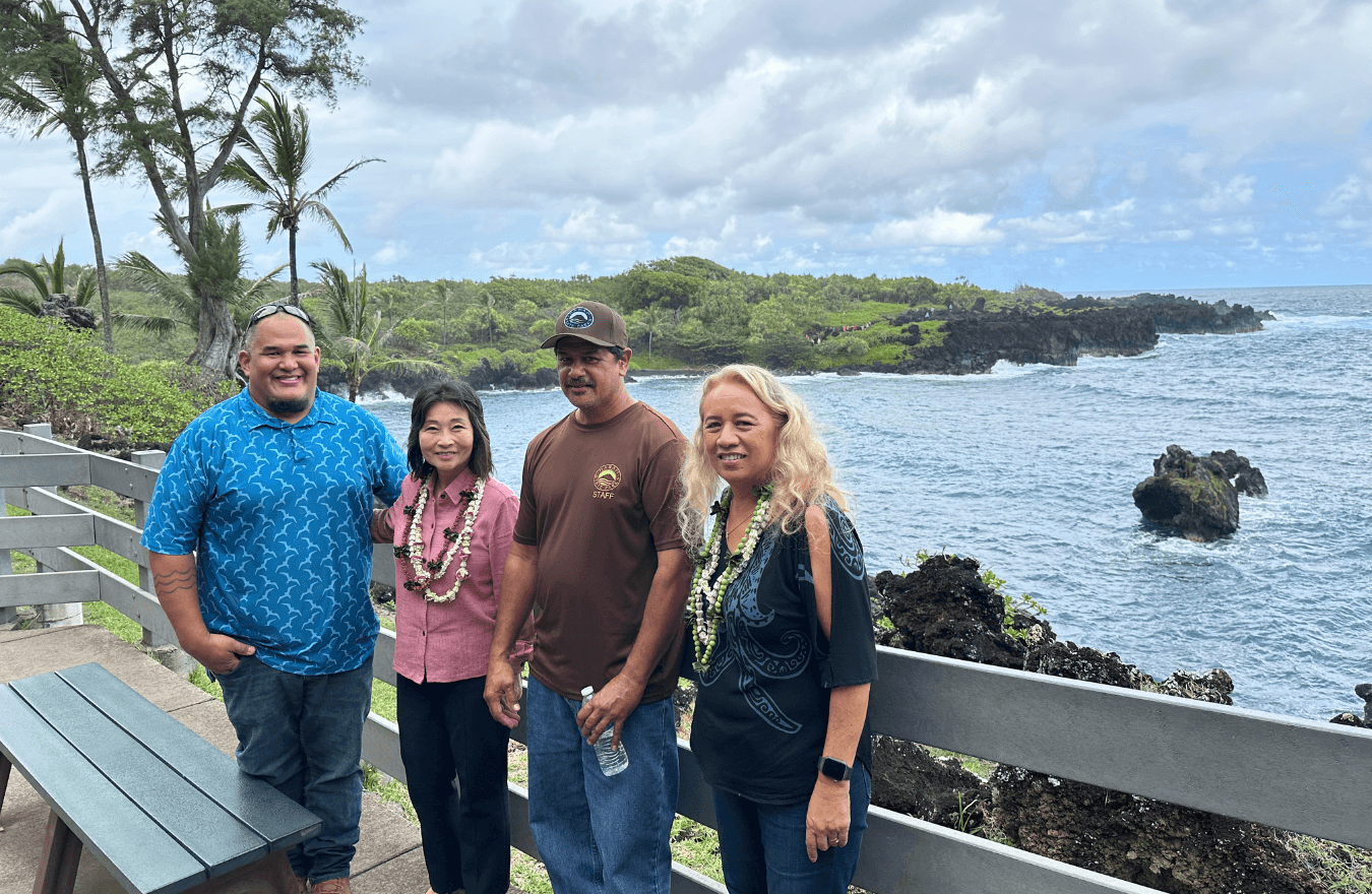 Lt. Gov. Sylvia Luke, a legislator, and community members standing in front of the ocean. 