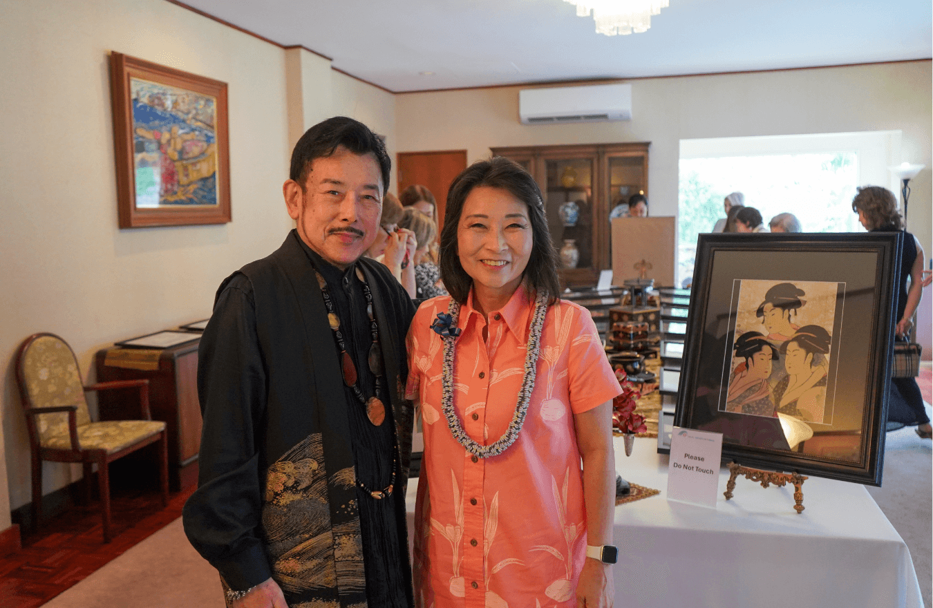 Lt. Gov. Sylvia Luke and a man smiling for a picture next to an art piece. 