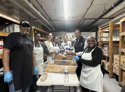 Democratic Leader Ranjeev Puri, state Representative Helena Scott and volunteers standing around a table packing food. Democratic Leader Ranjeev Puri, state Representative Helena Scott and volunteers standing around a table packing food.