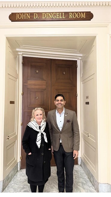 Democratic Leader Ranjeev Puri and U.S. Congresswoman Debbie Dingell in front of a large wooden door and sign that reads "John D. Dingell Room." Democratic Leader Ranjeev Puri and U.S. Congresswoman Debbie Dingell in front of a large wooden door and sign that reads "John D. Dingell Room."