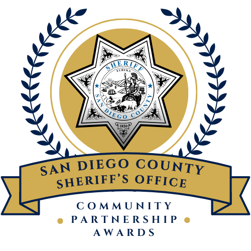 Sheriff star with gold and navy blue reef that says community partnership award and san diego county sheriff's office on a ribbon.