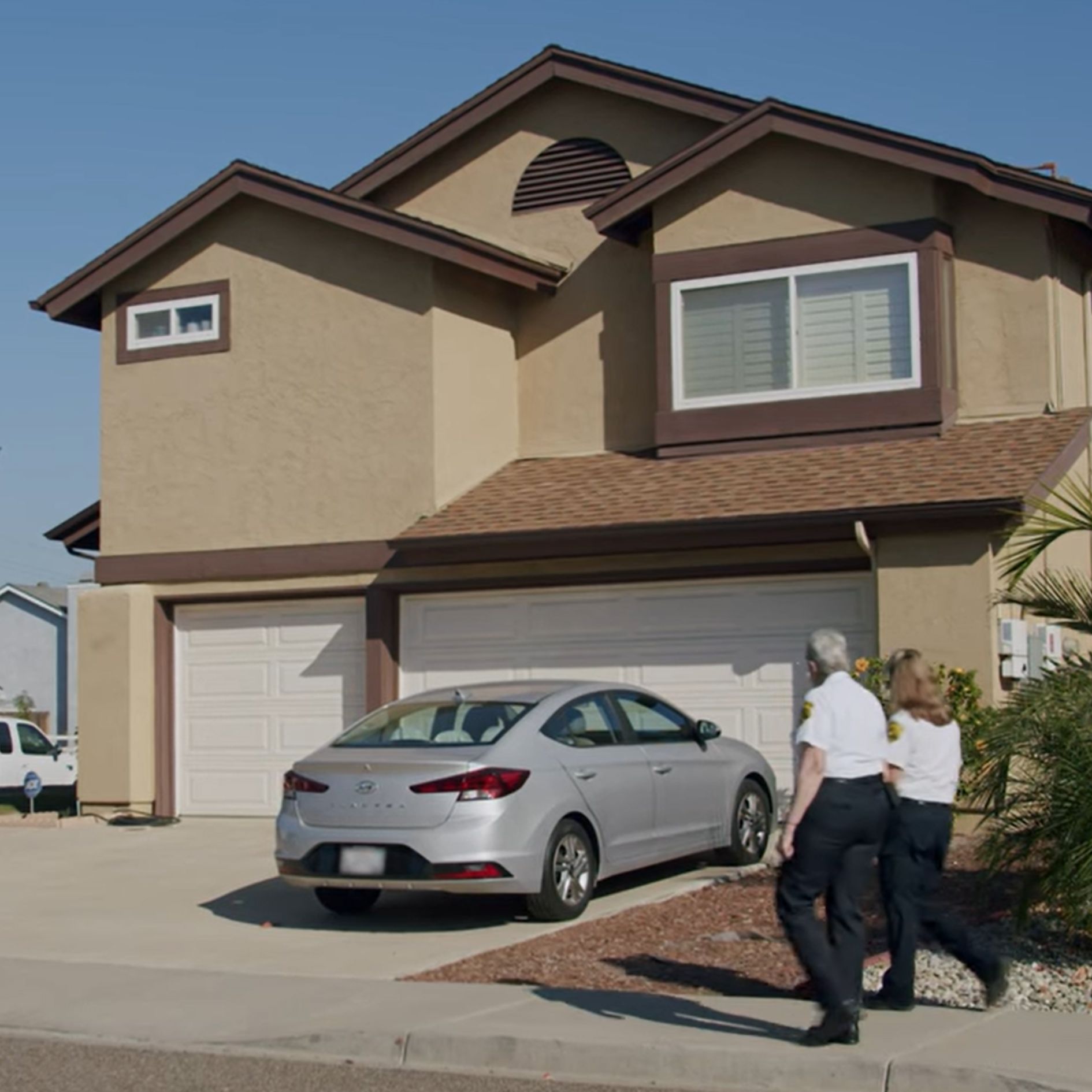 Volunteers walking in front of a house.