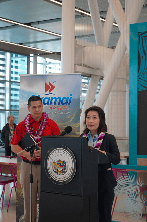 Lt. Gov. Sylvia Luke standing at a podium at an airport terminal. 