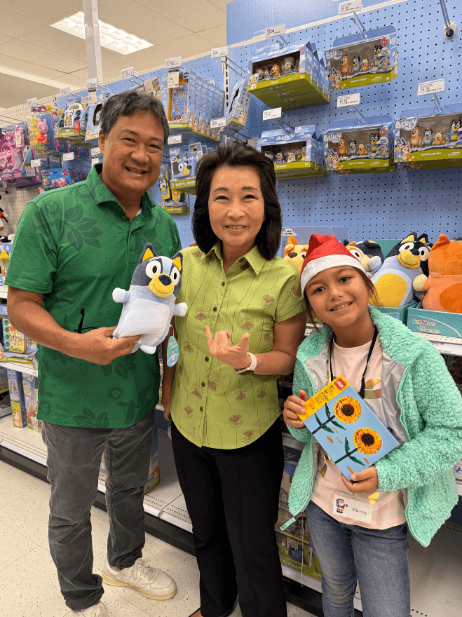 Lt. Gov. Sylvia Luke and group smiling for a photo while holding toys. 