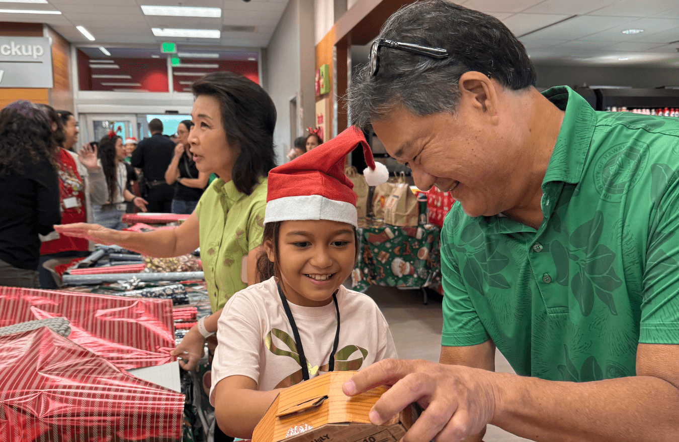 A man showing a little girl a toy and smiling. 