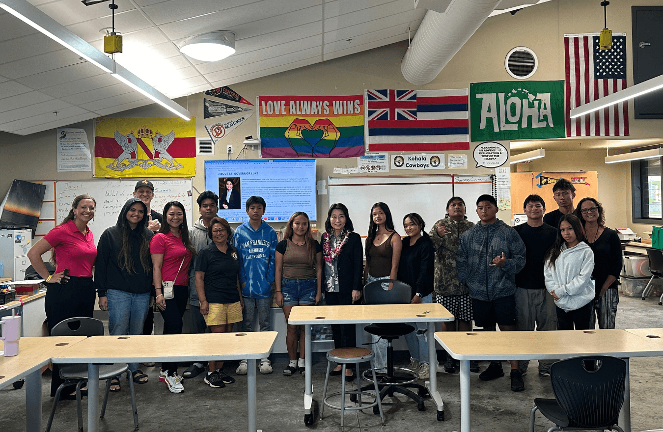 Lt. Gov. Sylvia Luke, group of students, and adults smiling for a group photo in a classroom. 