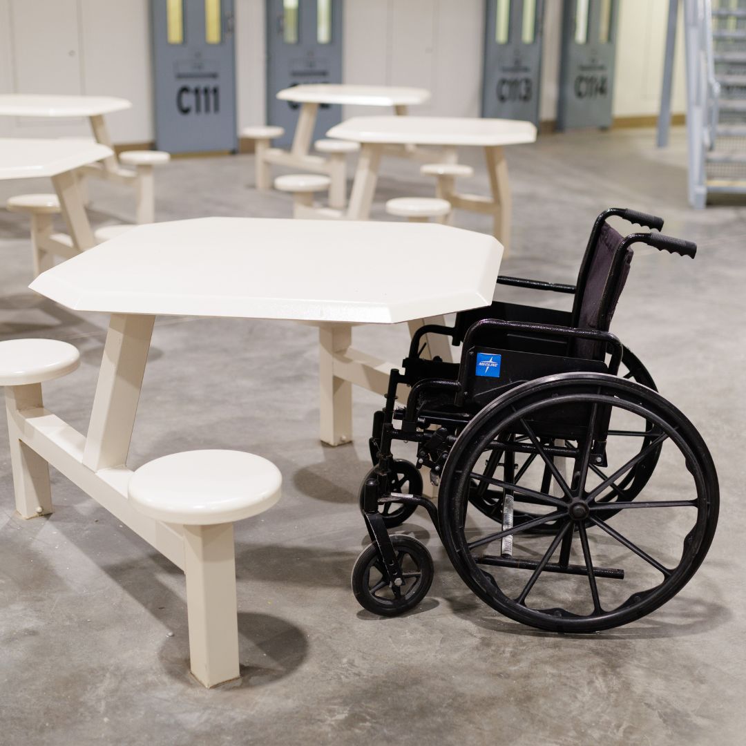 Senior Volunteer patrol giving a pie to an elderly women wearing a white shirt with a black and yellow patch.