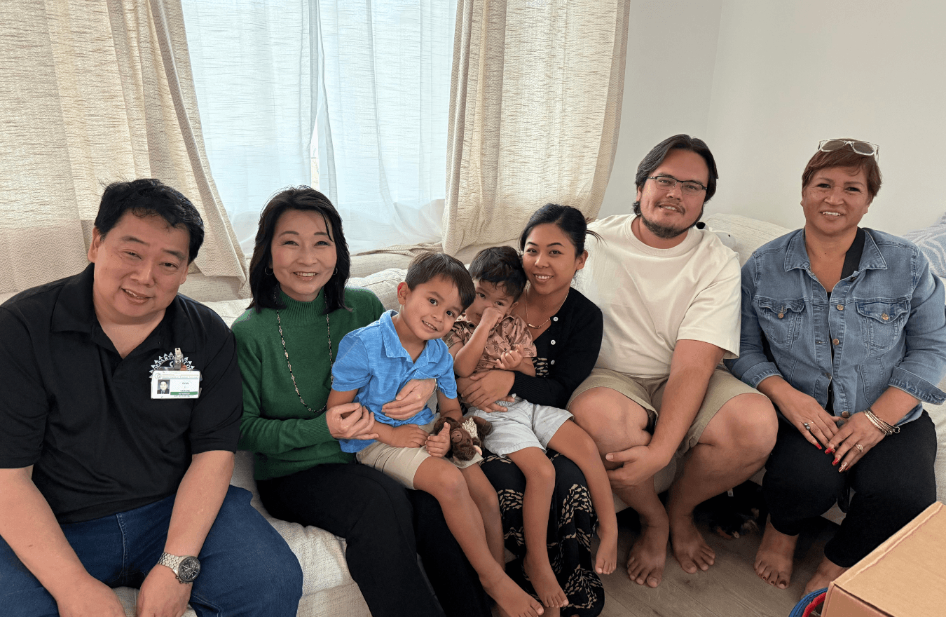 Lt. Gov. Sylvia Luke and group smiling for a group photo while sitting on a couch. 