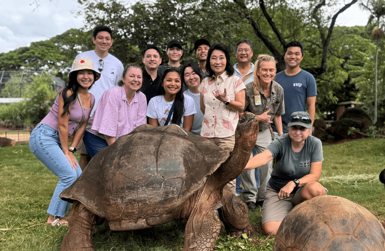 Lt. Gov. Sylvia Luke and group smiling while gathered for a group photo behind a large tortoise outdoors. 