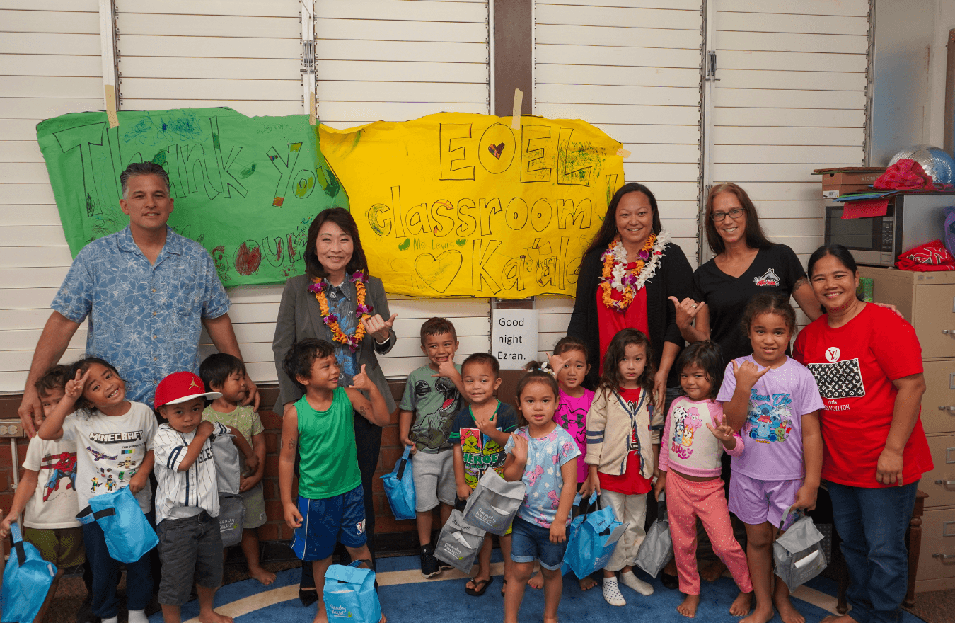 Lt. Gov. Sylvia Luke, teachers, and pre-k students smiling and holding up shakas in a Ready Keiki preschool classroom in Wahiawā, Oʻahu. 