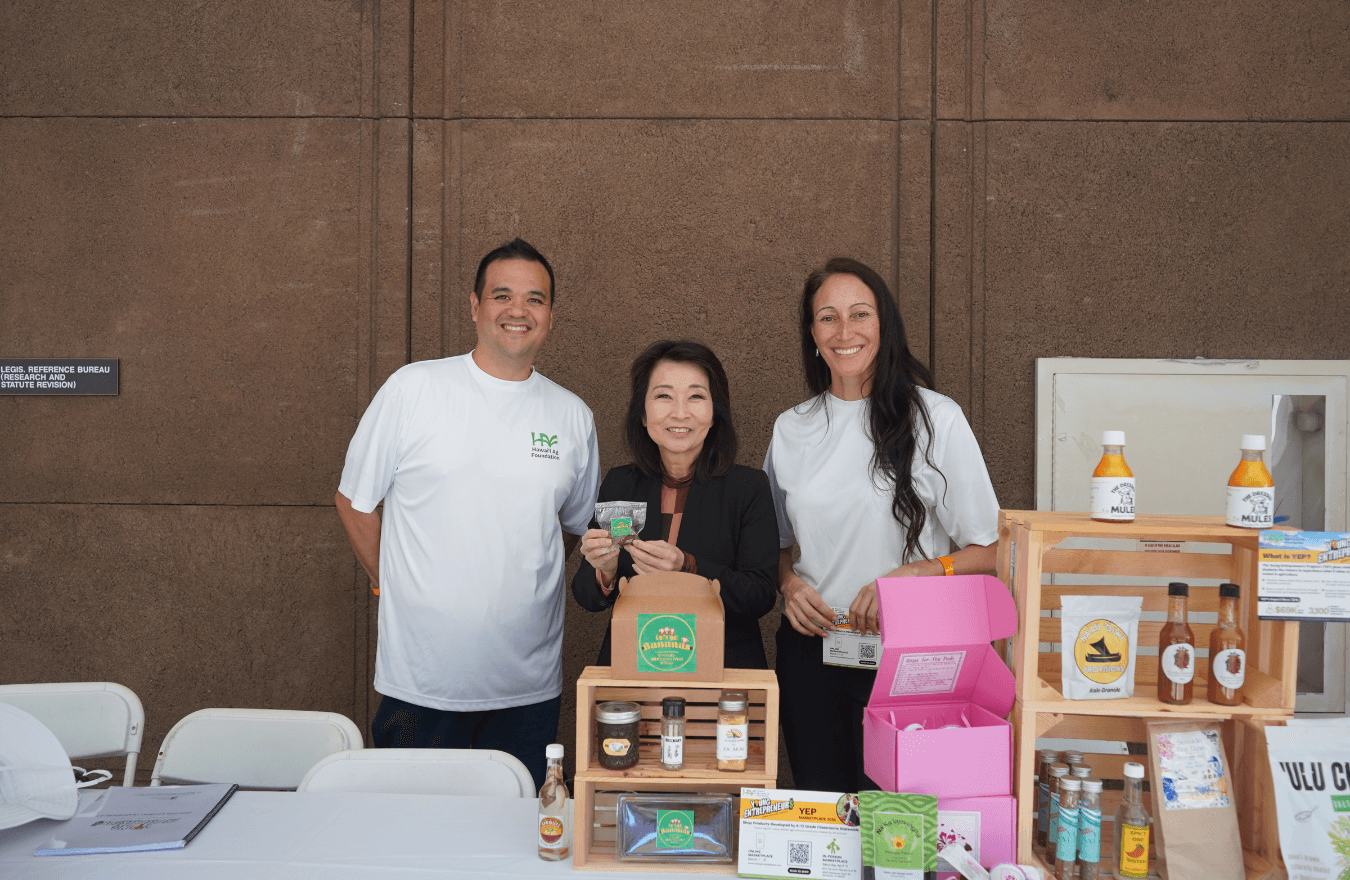 Lt. Gov. Sylvia Luke holding a small package and smiling with group. 