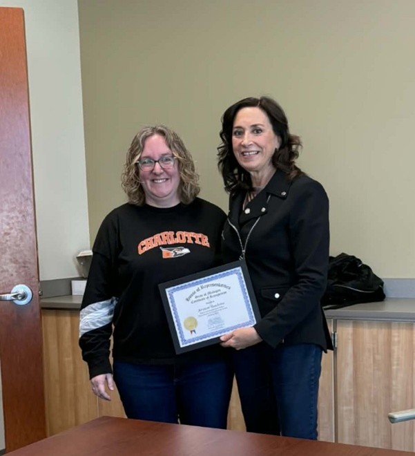 Michigan state Representative Angela Witwer presenting a framed certificate to Kristen Toadvine at Charlotte High School. Michigan state Representative Angela Witwer presenting a framed certificate to Kristen Toadvine at Charlotte High School.