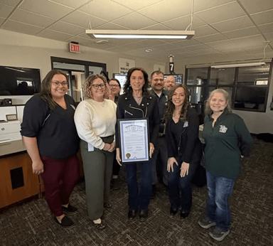 Michigan state Representative Angela Witwer presenting a framed tribute certificate to Kelley Flynn at Eaton County Central Dispatch. Michigan state Representative Angela Witwer presenting a framed tribute certificate to Kelley Flynn at Eaton County Central Dispatch.