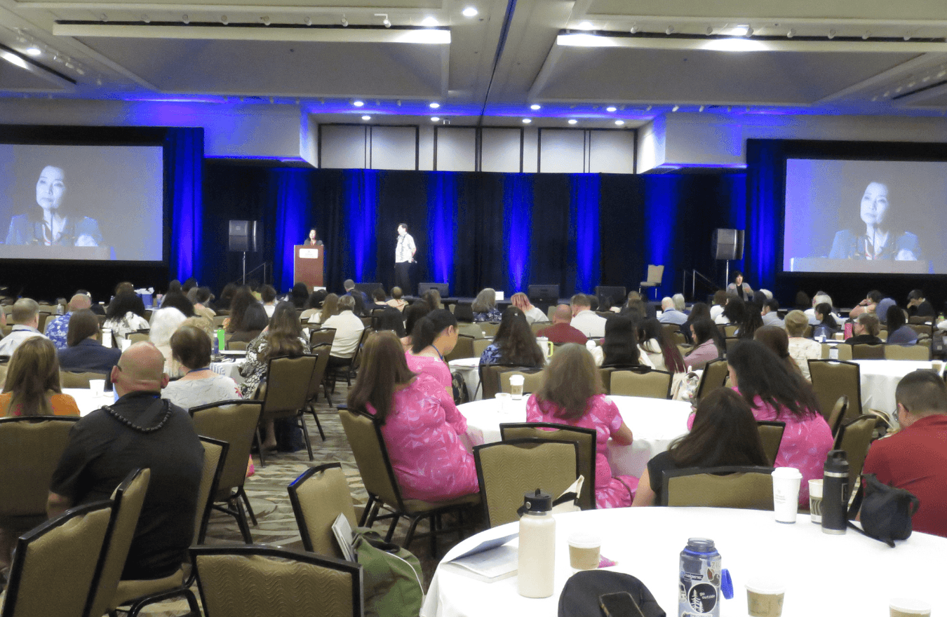 Lt. Gov. Sylvia Luke standing at a podium on stage speaking to a room full of people. 