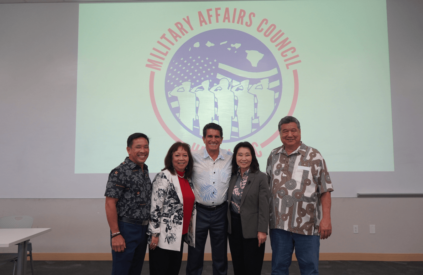 Lt. Gov. Sylvia Luke and group smiling for a group photo in front of a screen that says, “Military Affairs Council.” 