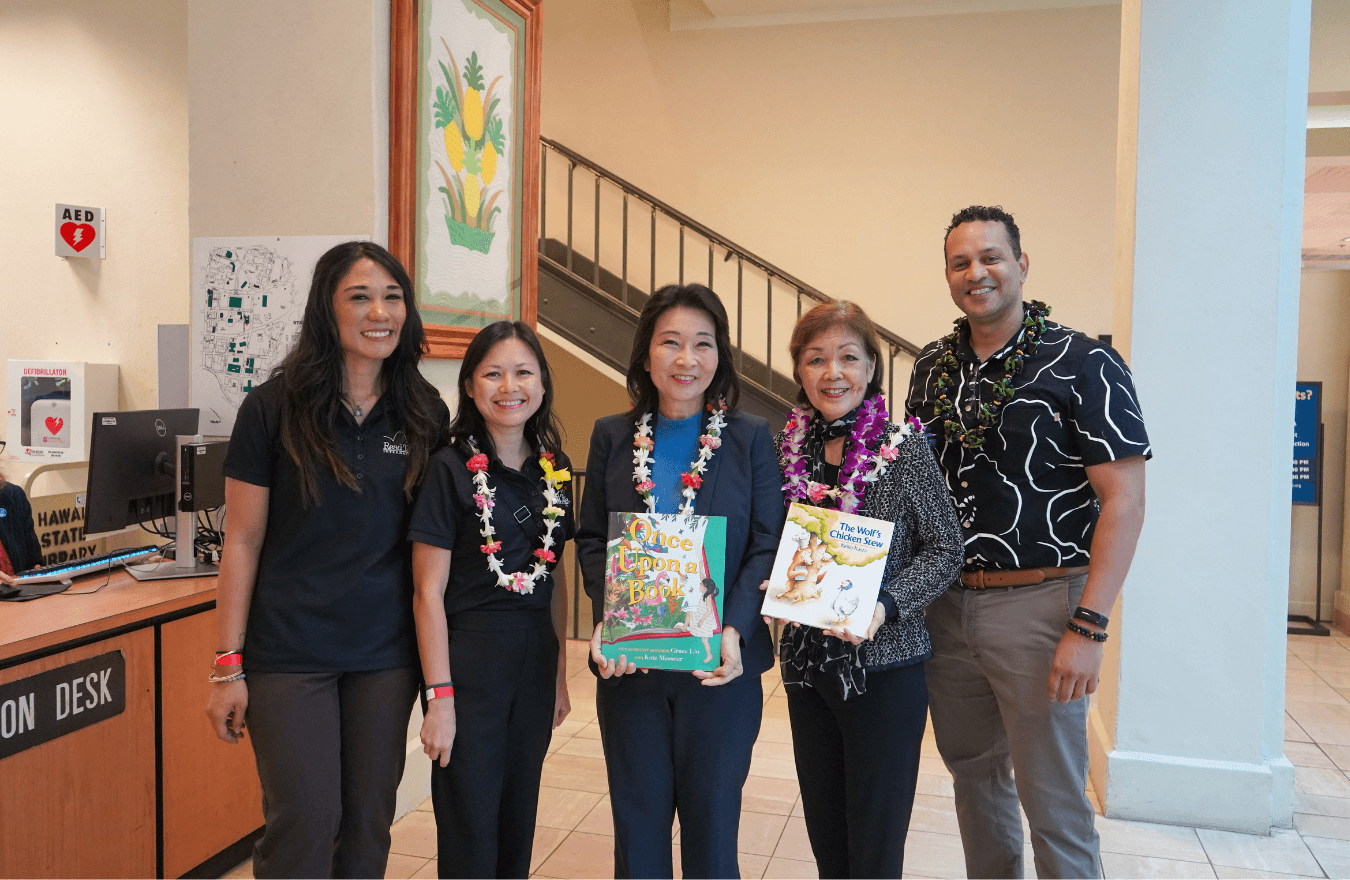 Lt. Gov. Sylvia Luke and a lady holding books while smiling for a photo with a group. 