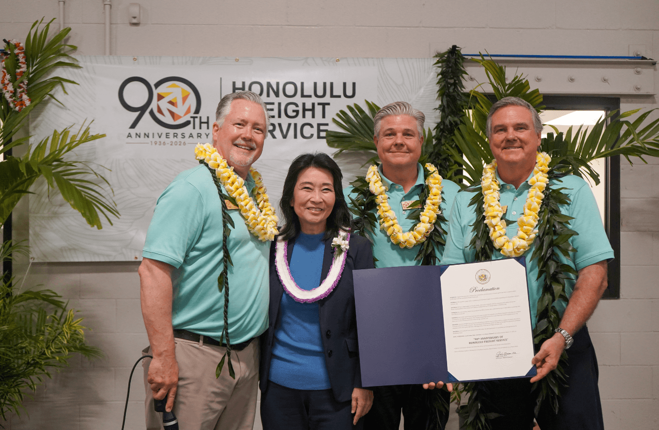 Lt. Gov. Sylvia Luke smiling with a group while one individual holds open a folder with a paper in it. 