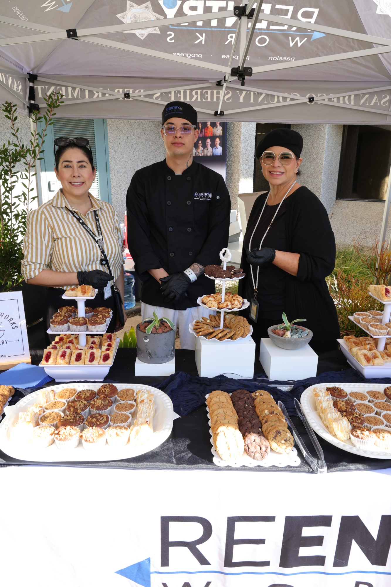Senior Volunteer patrol giving a pie to an elderly women wearing a white shirt with a black and yellow patch.