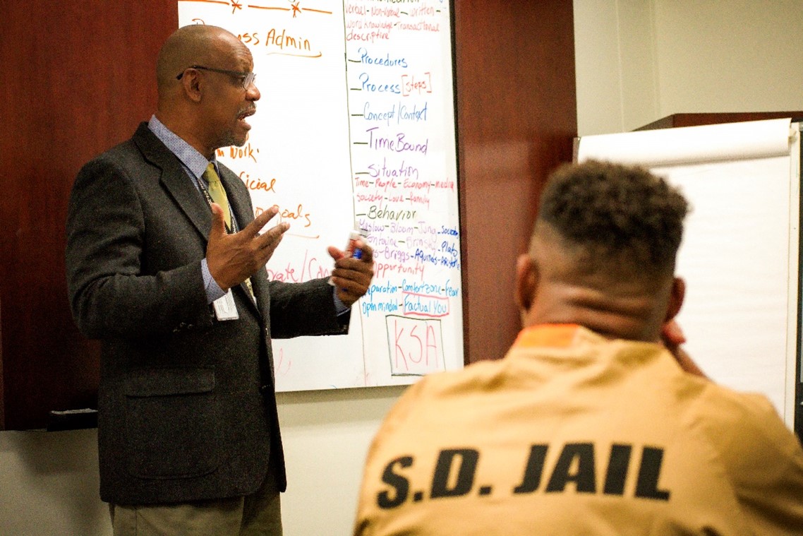 Ip looking at instructor with wite board.