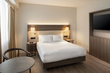 Double bedroom with cream headboard, double bed and sitting area