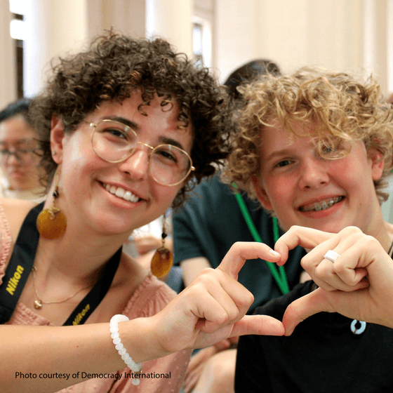 Image of two young people making heart with their hands