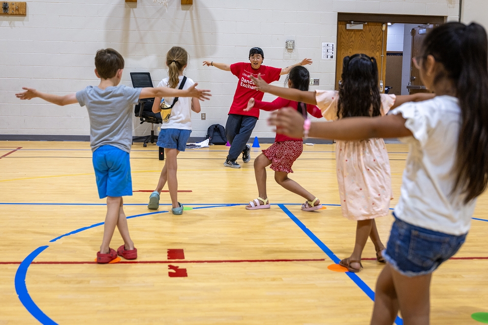 Student instructor Pa Ying Gia Thao leads a group of children in a dance activity.
