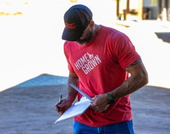 Man wearing a red branded shirt with the words home grown.