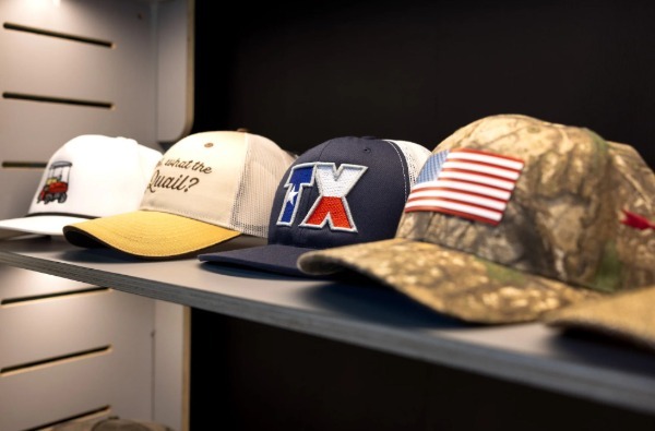 Multiple Hats lined up with each other featuring embroidered on logos including one with the flag of the united states.