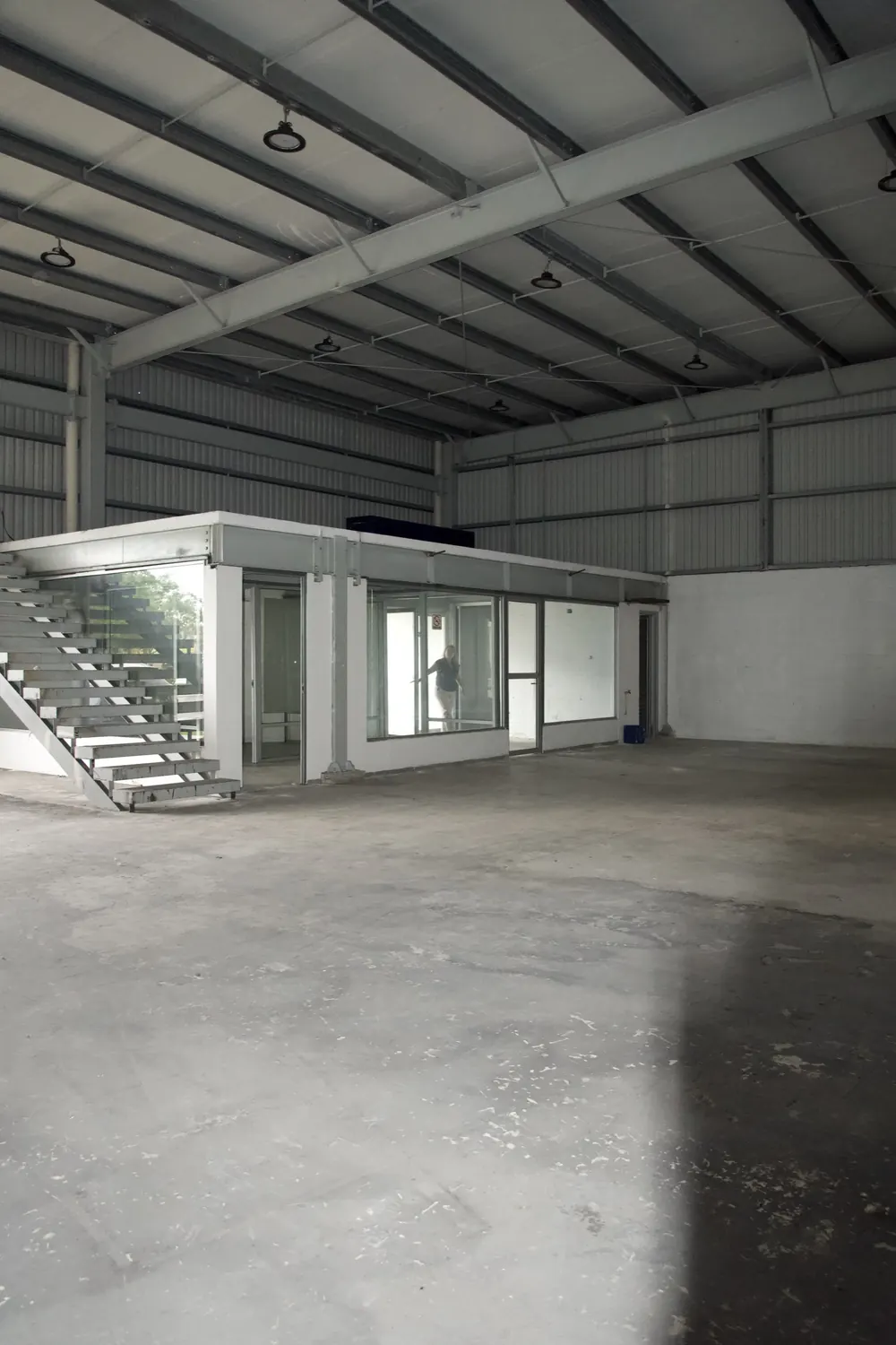 Nave con oficina de cristal en la mezzanine