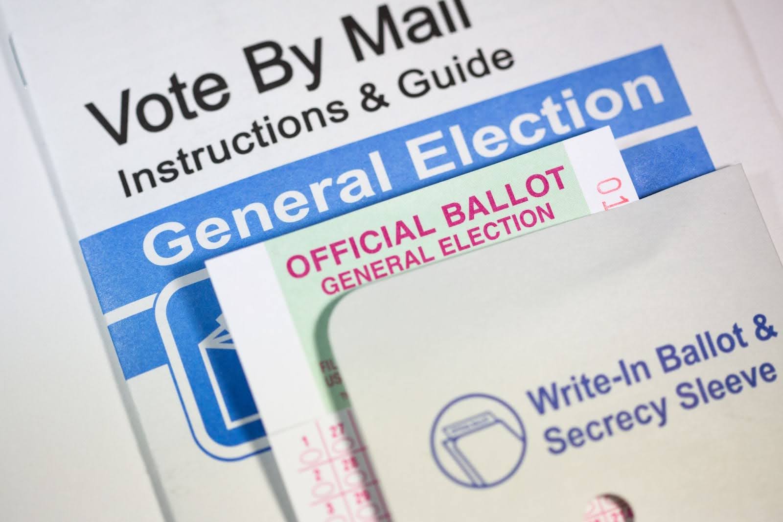 Close-up view of vote-by-mail instructions and guide, official ballot, and privacy sleeve. Close-up view of vote-by-mail instructions and guide, official ballot, and privacy sleeve.