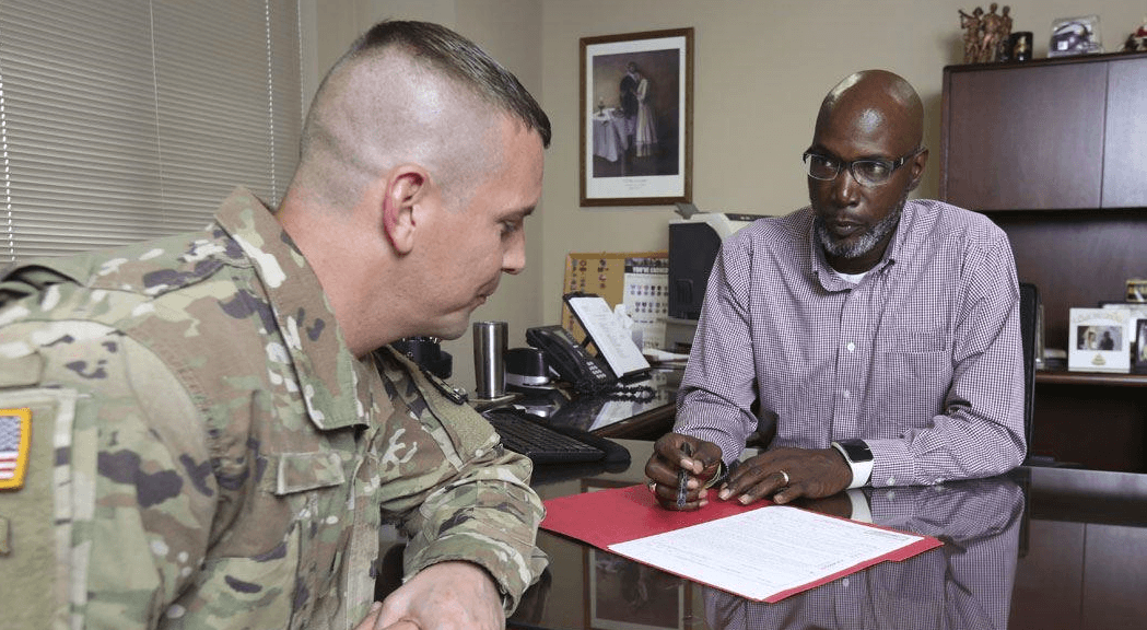 A man helping a veteran with paperwork