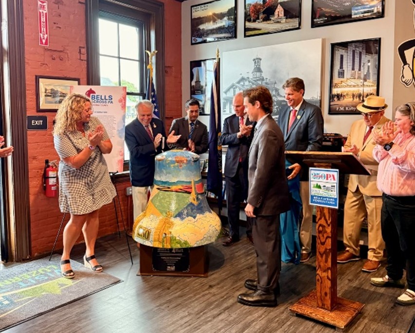 A picture of Rep. Pashinski with other local officials clapping at the unveiling of the bell.