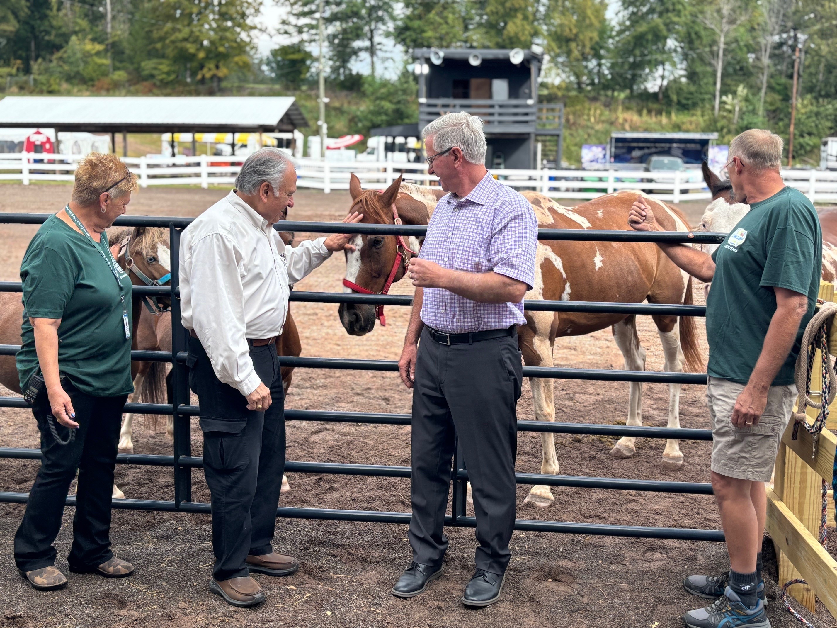 Rep. Pashinski, Sec. Redding and fair volunteers are greeted by two horses.