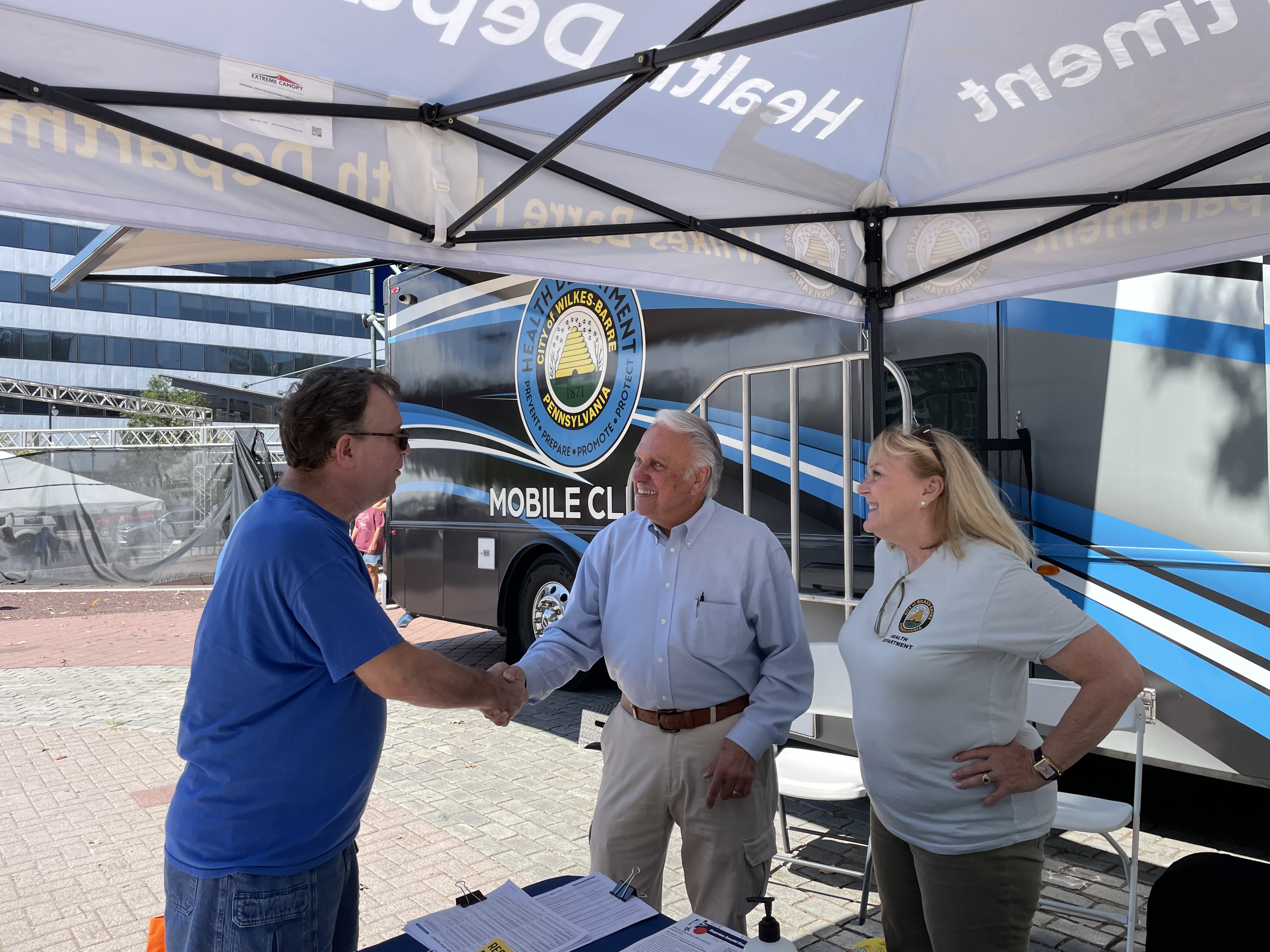 Rep. Pashinski shakes hand with a volunteer from a health clinic.