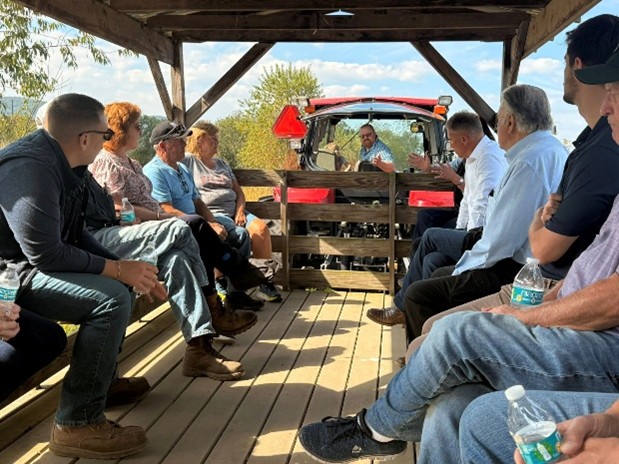 A picture of Rep. Pashinski and others riding in a hay wagon.