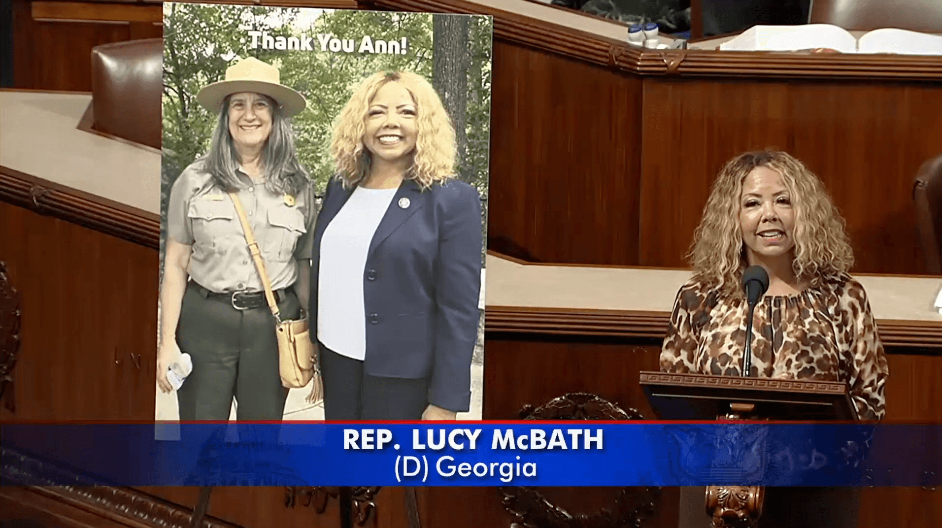 Rep. McBath speaking from the House floor beside a poster that reads "Thank you Ann!"