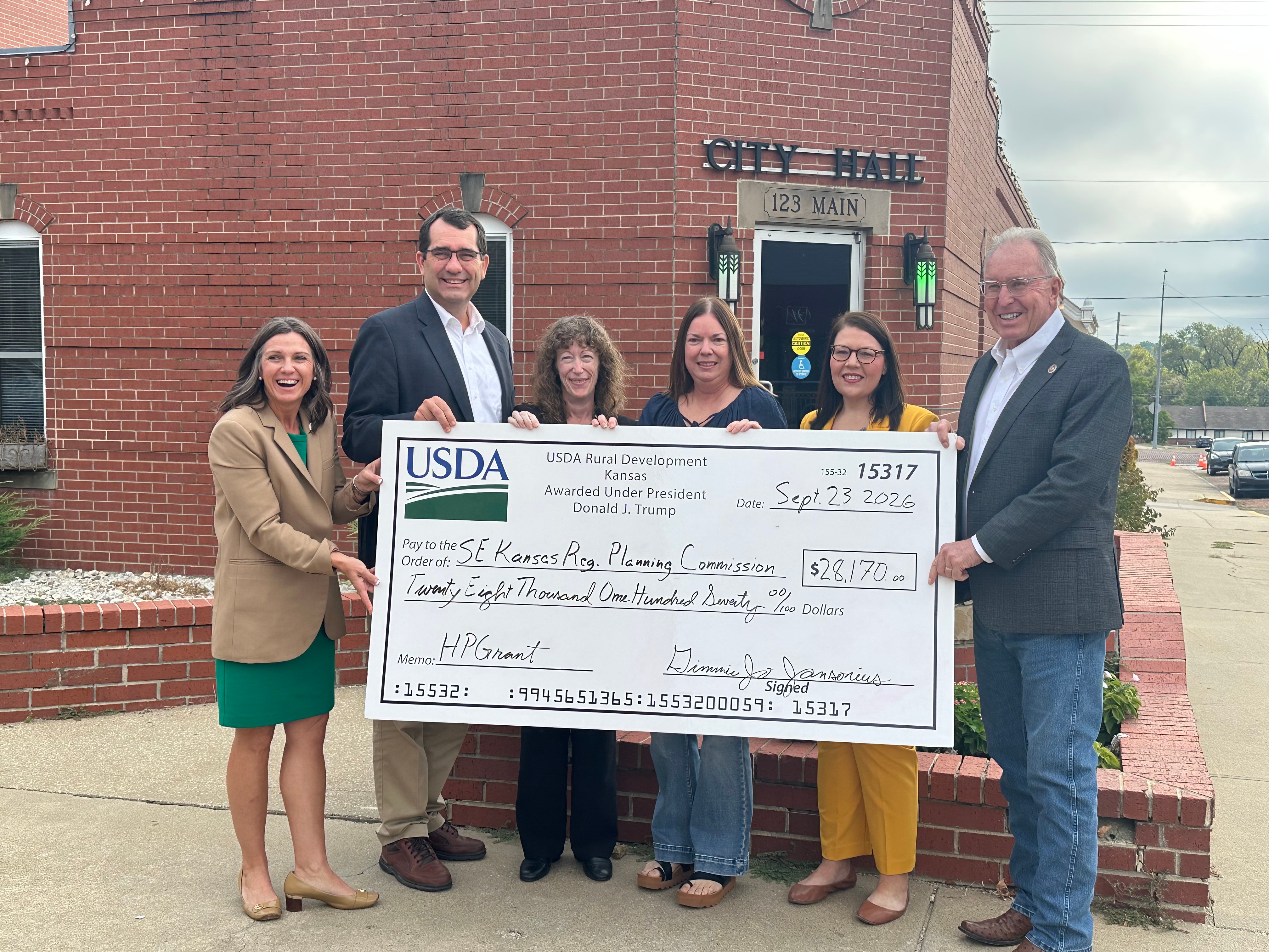 USDA officials present a $28,170 check to the Southeast Kansas Regional Planning Commission outside Fort Scott City Hall