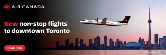 Air Canada advertisement showing a plane flying over a city skyline at sunset with the CN Tower visible. Text reads, "New non-stop flights to downtown Toronto." A "Book now" button is included. Star Alliance logo is at the bottom.