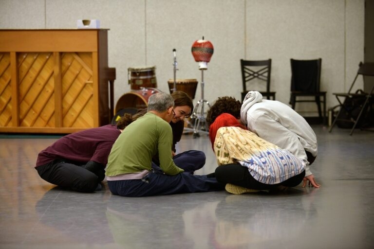 People sitting in a circle together in a music room.